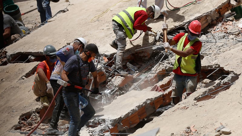 Los equipos de rescate buscan entre los escombros de un edificio derrumbado dos días después...