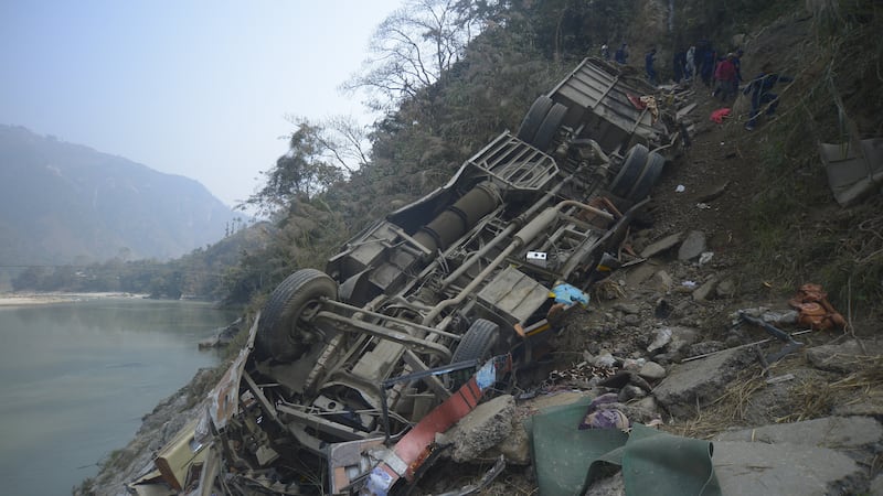 Los restos de un autobús se ven en la orilla del río Trishuli después de que el vehículo se...