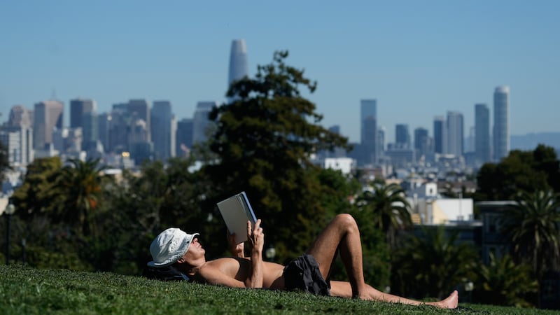 Clive Lovejoy lee un libro recostado sobre el césped el miércoles 18 de marzo de 2026, en...