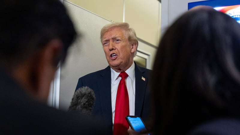 El presidente Donald Trump habla con reporteros a bordo del Air Force One rumbo a su mansión...