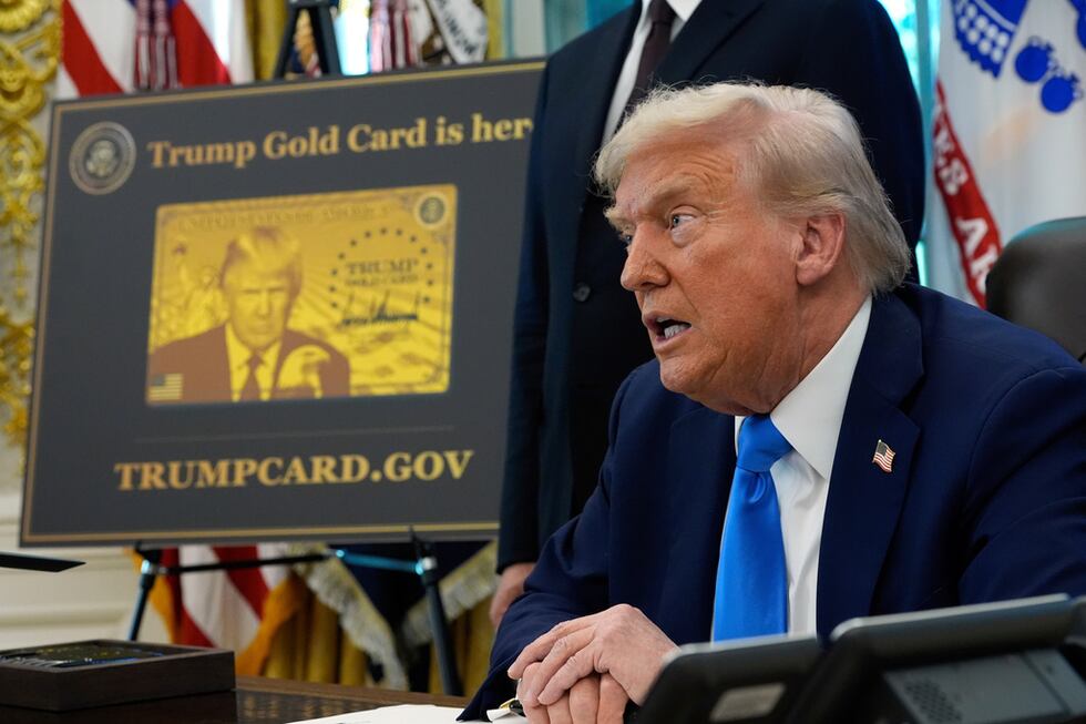 En la imagen, un cartel muestra la Tarjeta Dorada de Trump mientras el presidente Donald Trump...