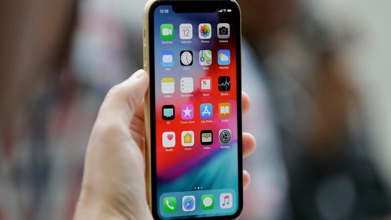 FILE - An Apple iPhone XR is held at the Steve Jobs Theater after an event to announce new...