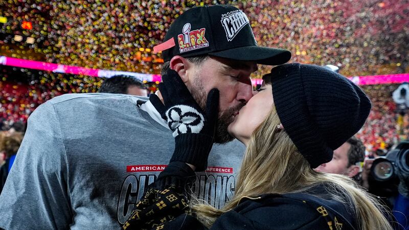 El tight end de los Chiefs de Kansas City, Travis Kelce, y Taylor Swift se besan tras el...